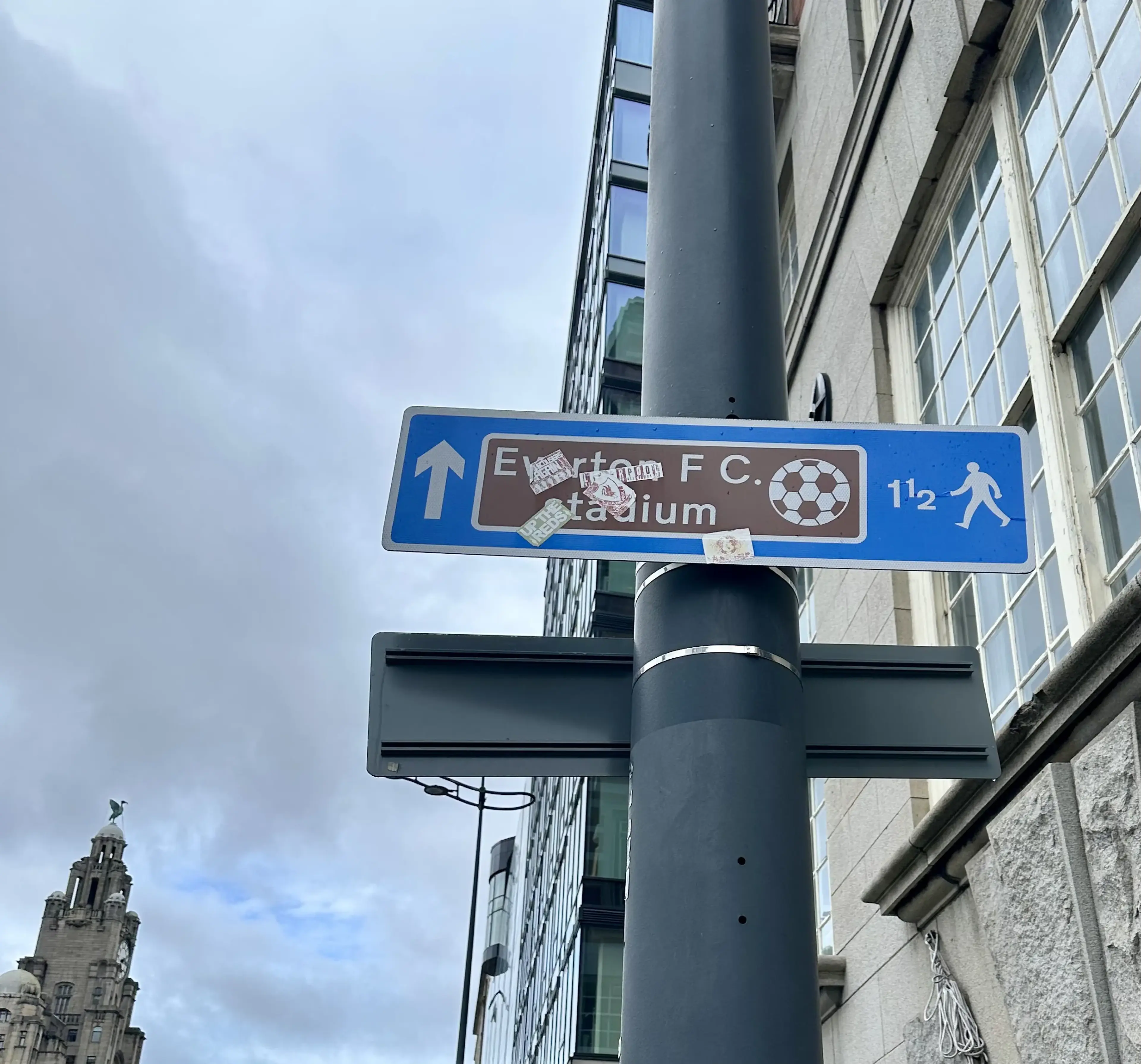 Señalamiento de tráfico que guía al estado de Everton, pero cubierto en calcas del Liverpoool